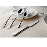 Fork, knife, and two spoons placed on elegant white dishware over a beige-striped tablecloth.